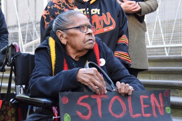 Eunice Wright in a wheelchair at a rally for the Stolen Generations outside Victorian Parliament House.