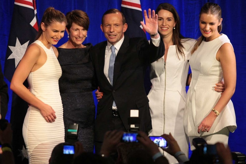 Tony Abbott celebrates on stage with wife Margie and their daughters.