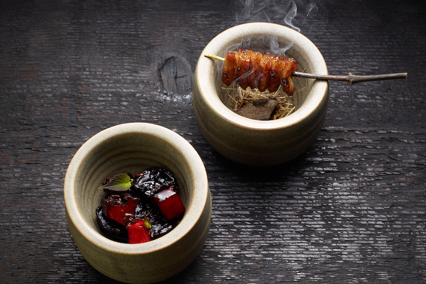 Three small bowls of delicate food sit atop a black benchtop 