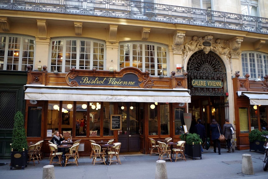 A woman sits outside Bistrot Vivienne, a traditional Parisian bistro.