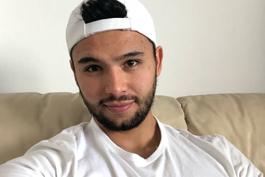 a young man in a backwards cap taking a selfie