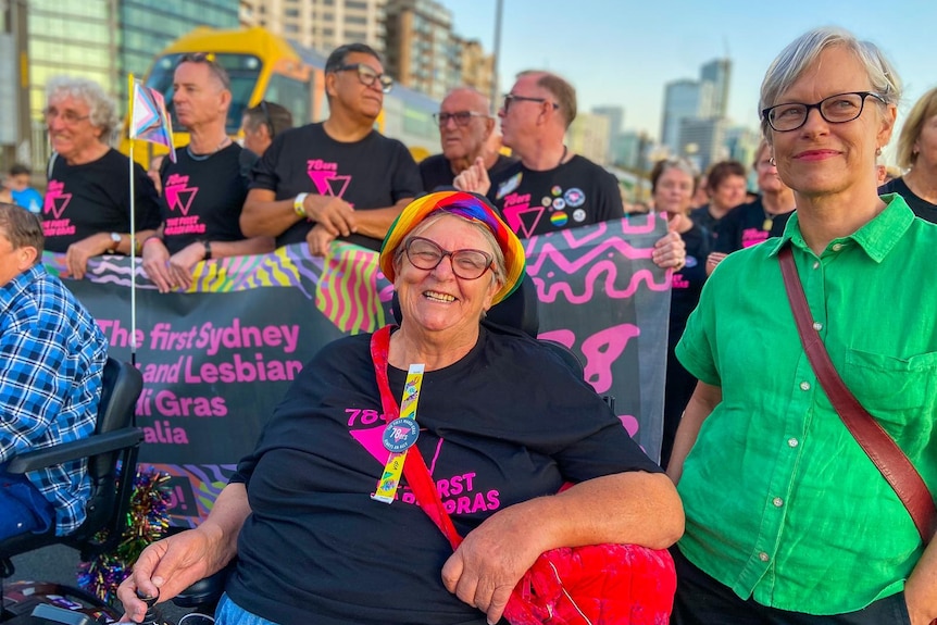 Two women smile as they walk across the Sydney Harbour Bridge for World Pride