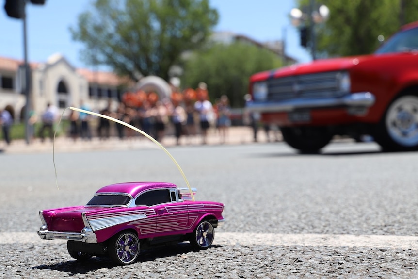 A toy car in front of the city cruise.