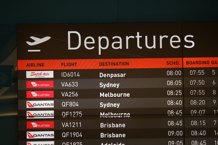 An airport departure board showing multiple flights, with the Batik Air flight to Denpasar at the top.