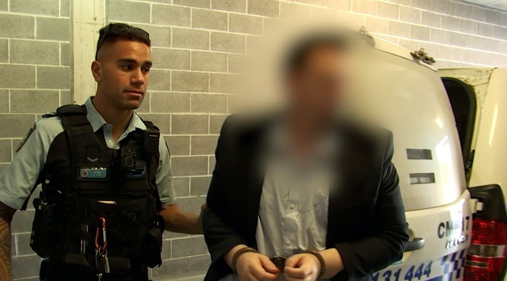 Scott Maxwell Jeffries, right and face blurred, arrested over Western Sydney rental scheme by NSW police officer who stands left