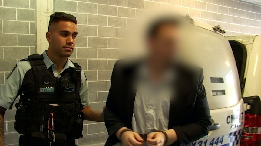 Scott Maxwell Jeffries, right and face blurred, arrested over Western Sydney rental scheme by NSW police officer who stands left