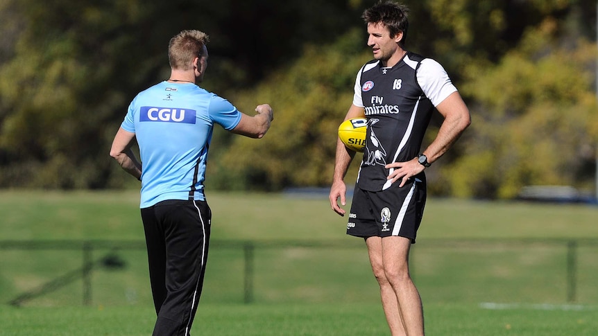 Collingwood ruckman Darren Jolly (right) speaks with coach Nathan Buckley at training in May 2013.