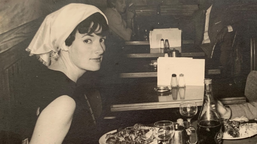 a black and white photo of a woman at a diner