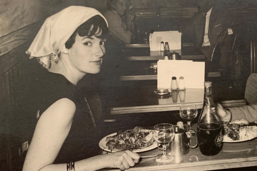 a black and white photo of a woman at a diner