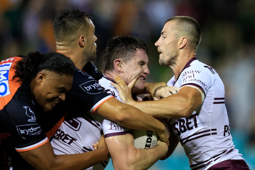 Two NRL players collide during a Manly-Wests Tigers trial game