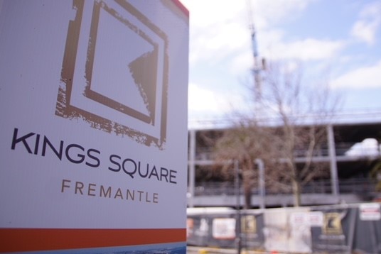A sign saying Kings Square, Fremantle with building construction and a crane in the background.