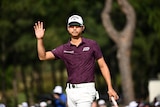 Australian golfer Min Woo Lee waves to his fans in the crowd after finishing his round.