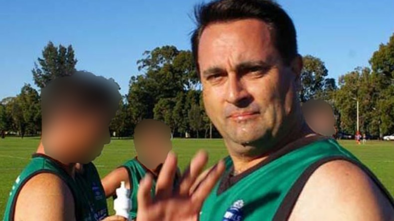 Accused Claremont serial killer Bradley Robert Edwards raises his hand while standing on a football oval with three teammates.