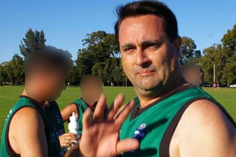 Accused Claremont serial killer Bradley Robert Edwards raises his hand while standing on a football oval with three teammates.