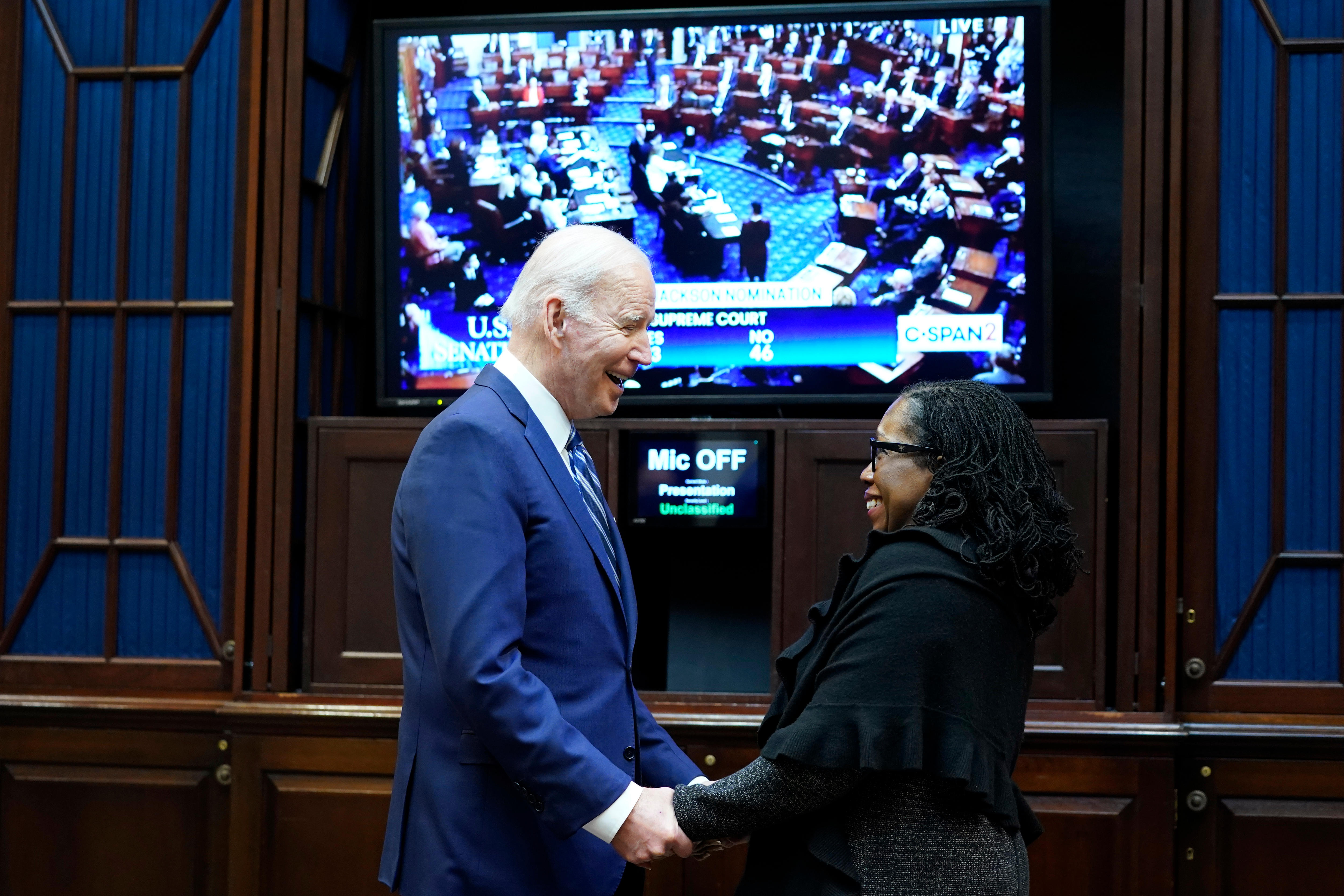 President Joe Biden holds hands and talks with Supreme Court nominee Judge Ketanji Brown Jackson as they watch the Senate vote.