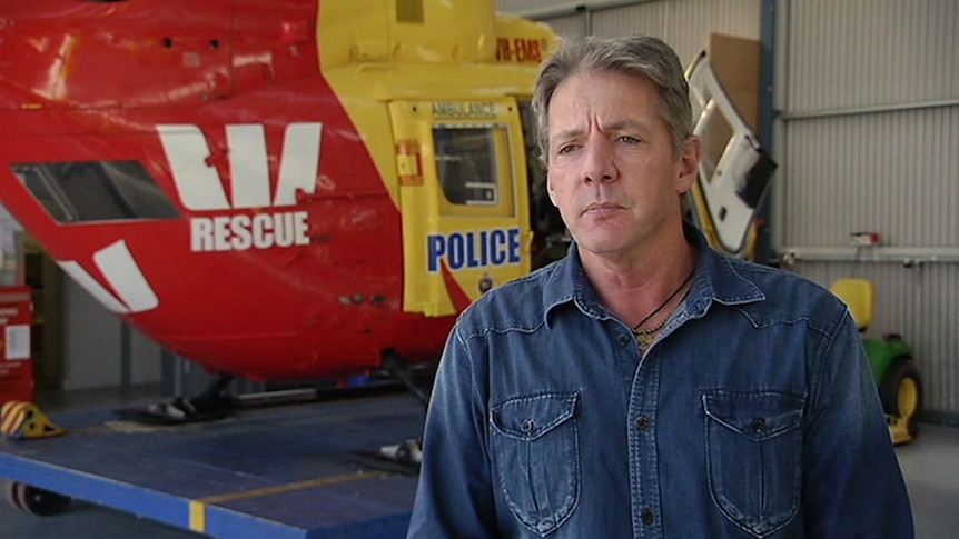 Roger Corbin in front of rescue helicopter.