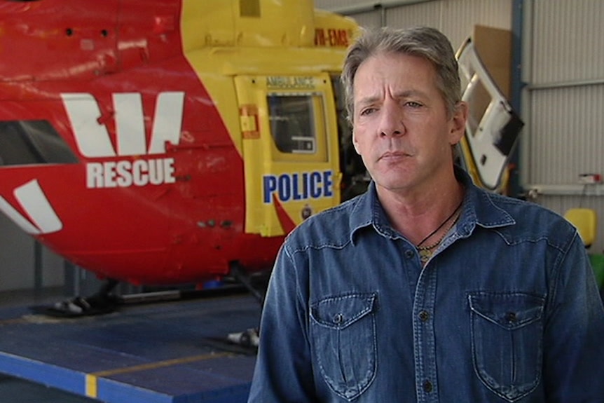 Roger Corbin in front of rescue helicopter.