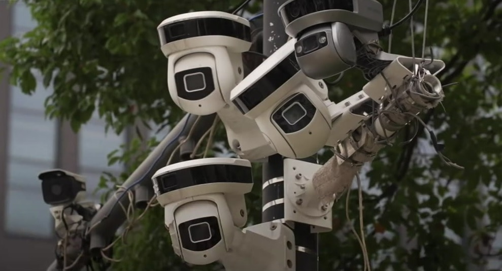 A group of surveillance cameras on a pole.