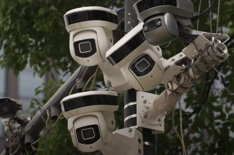 A group of surveillance cameras on a pole.