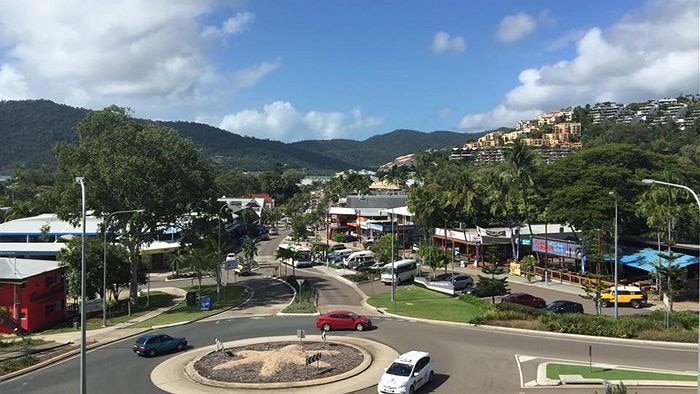 Cars driving around a roundabout near main street of Airlie Beach.