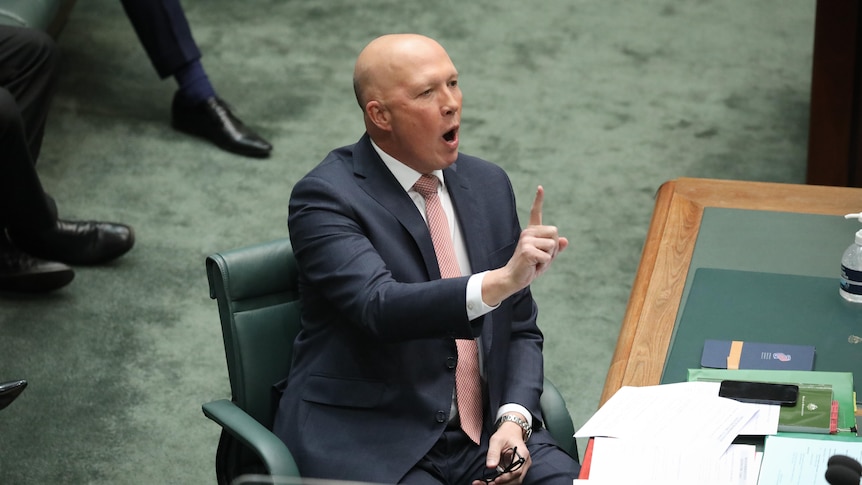 Peter Dutton holds one finger up while sitting in the house of representatives