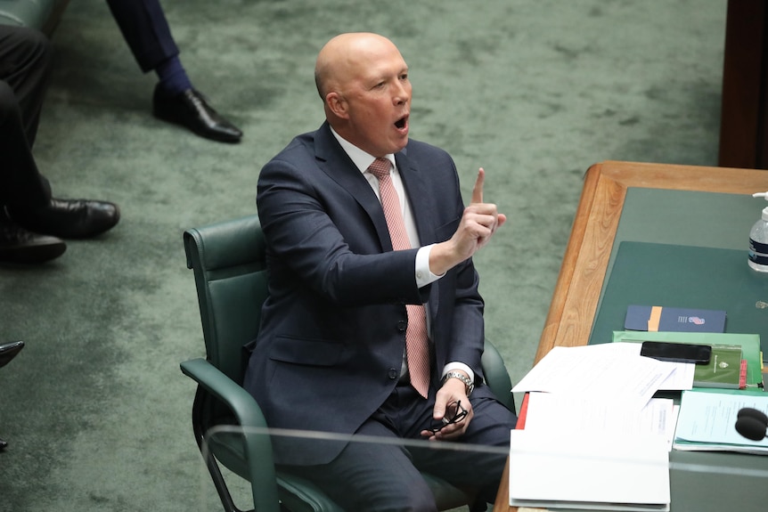 Peter Dutton holds one finger up while sitting in the house of representatives