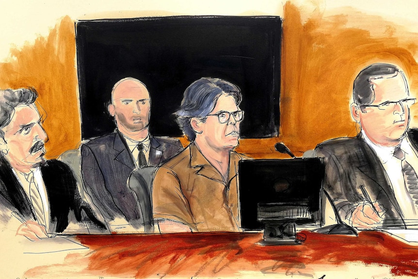 An artist's sketch shows Mr Raniere with his hair cut short surrounded by lawyers.