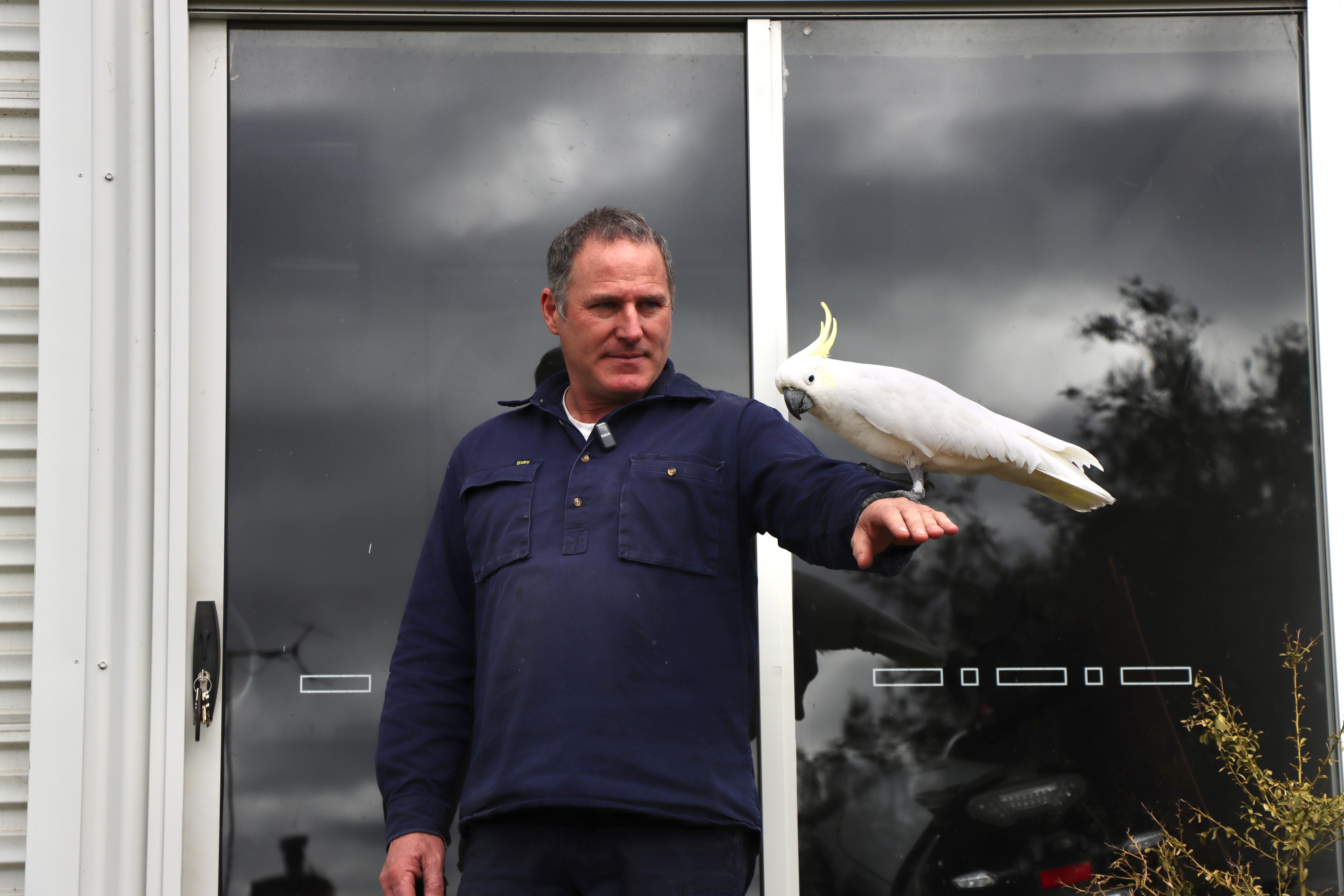Dan Bolwell outside his workshop with his cockatoo Taka.