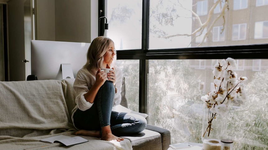 Woman in an apartment looking down onto the street