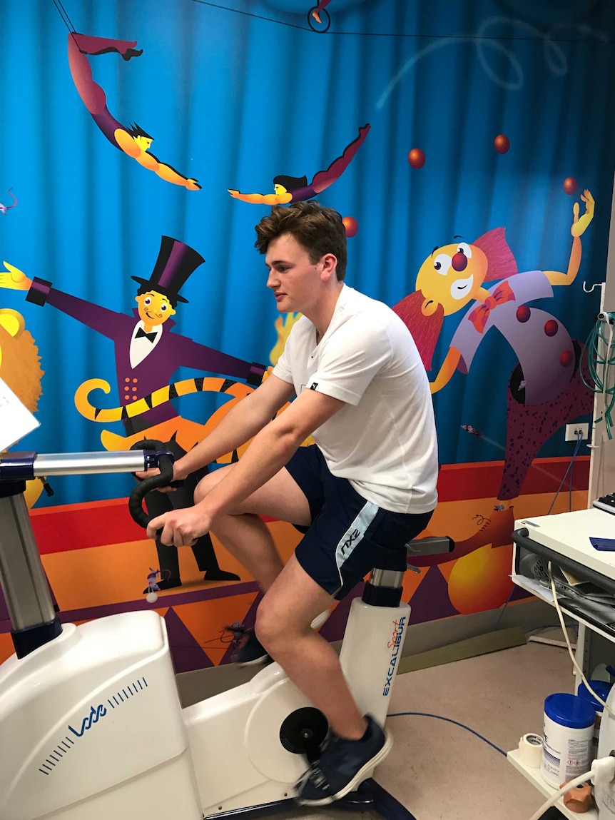 Fourteen-year-old Morgan Little rides a stationary bike.