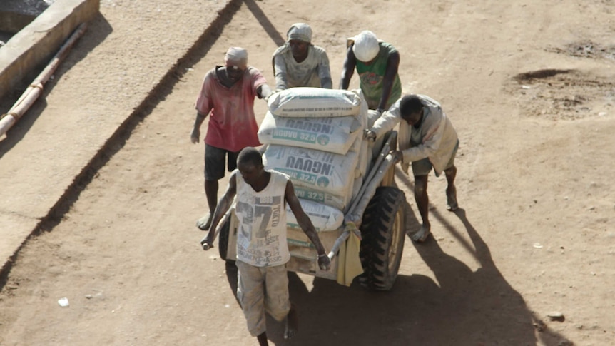 Workers push a cart on the island of Lamu