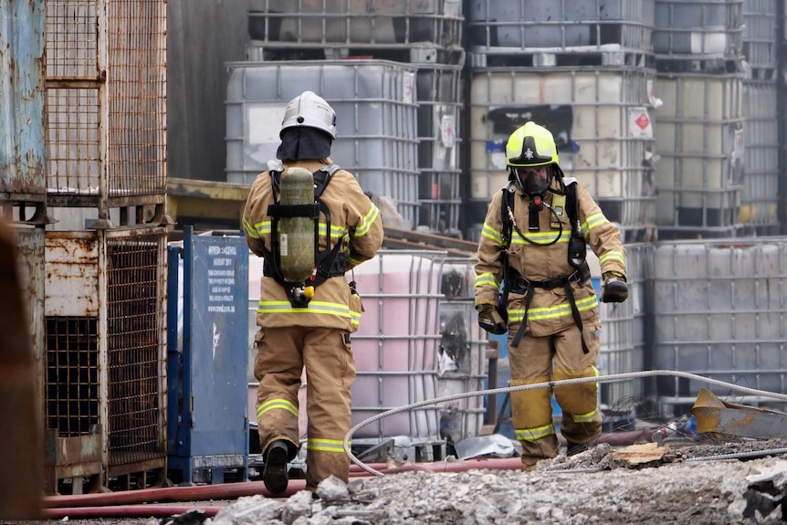 Firefighters wear gas masks at the scene of a fire.