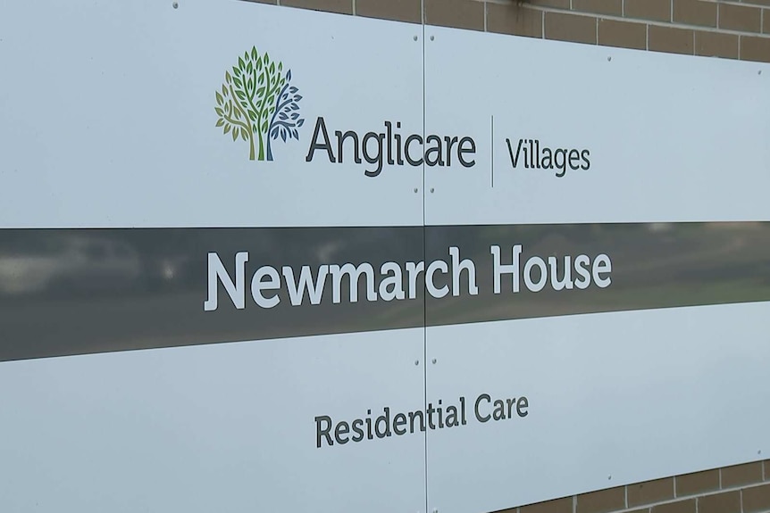 An outdoor sign on the wall staying Newmarch House.