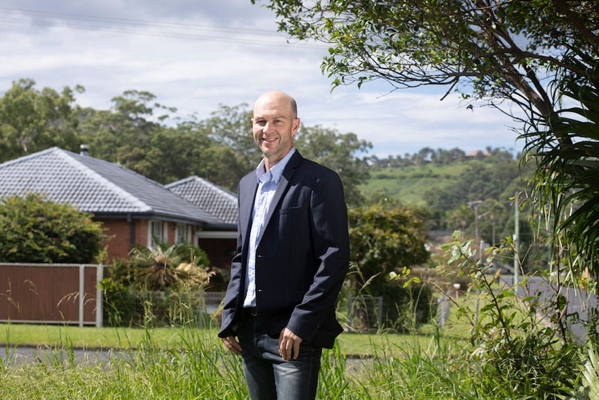 Tim Nott, a local politician poses for a photo outside a housing estate.