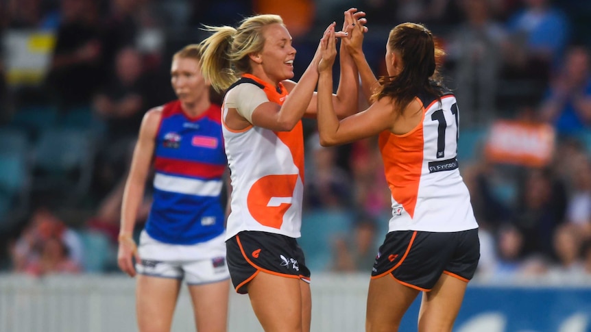 Aimee Schmidt of the Giants (R) celebrates her goal against Western Bulldogs at Manuka Oval.