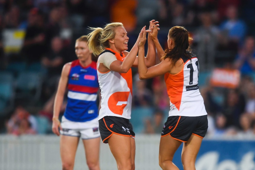 Aimee Schmidt of the Giants (R) celebrates her goal against Western Bulldogs at Manuka Oval.