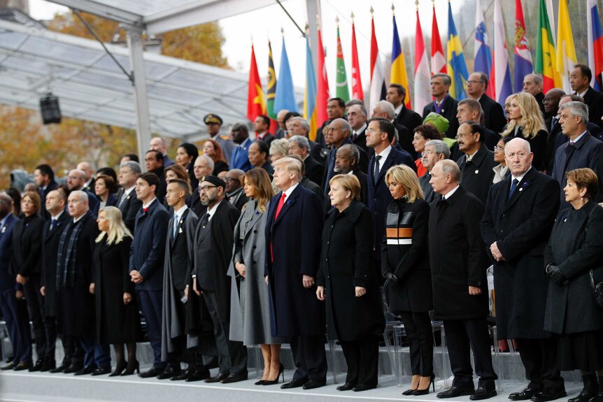 World leaders stand on podium to mark minute of silence