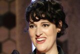 Actress Phoebe Waller-Bridge accepts the Golden Globe for best actress in a comedy series wearing a black flecked suit.