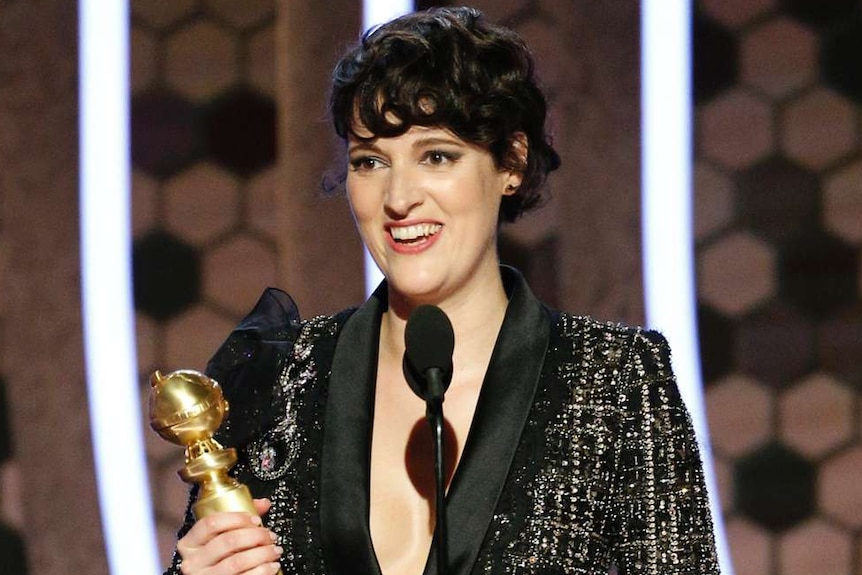 Actress Phoebe Waller-Bridge accepts the Golden Globe for best actress in a comedy series wearing a black flecked suit.