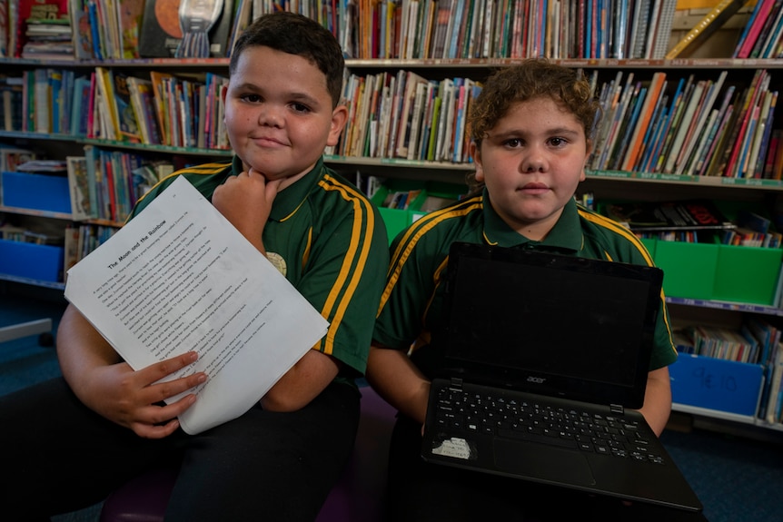 Two children in school uniform sitting and looking annoyed.