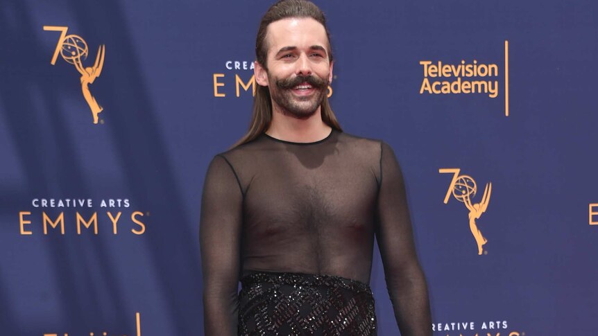 Jonathan Van Ness wears a black mesh dress with high chunky ankle boots on the red carpet