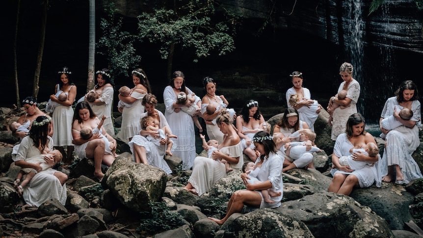 A group of women photographed breastfeeding their children