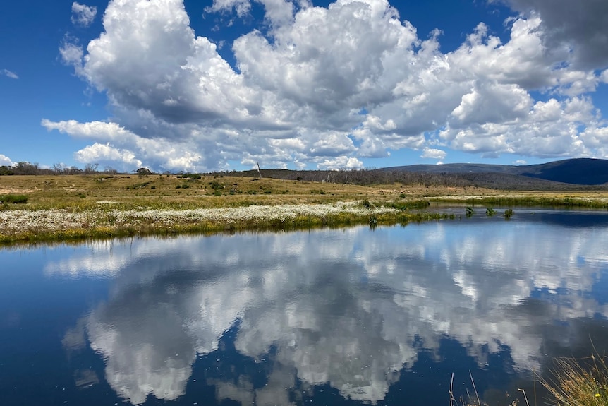 a river with the sky reflecting on the water