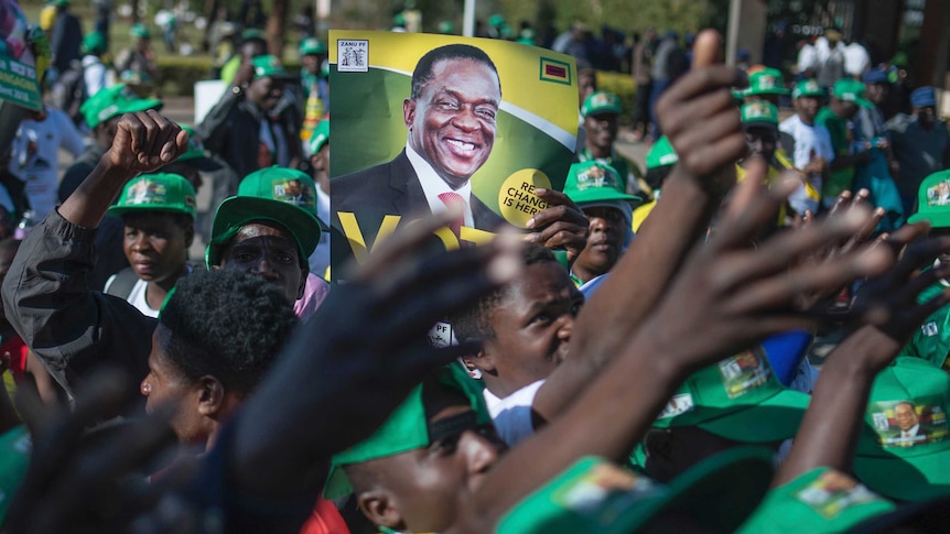 Supporters of Ruling party ZANU-PF at election rally hold a poster of Zimbabwean President Emmerson Mnangagwa