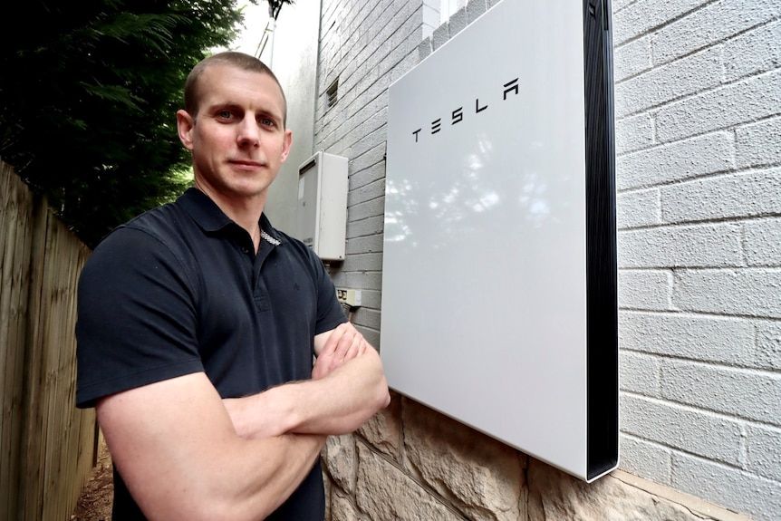 a man outside a house with a tesla