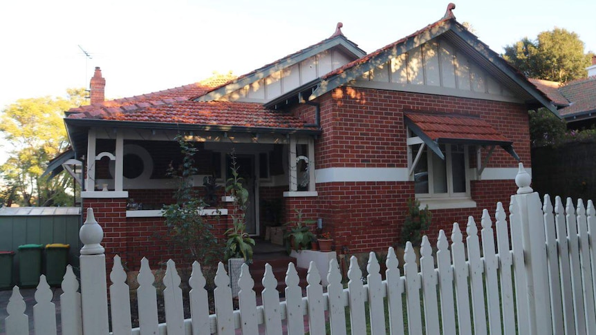 A wide shot of the front of Bob Hawke's childhood home in West Leederville, a brick and rile house with a white picket fence.