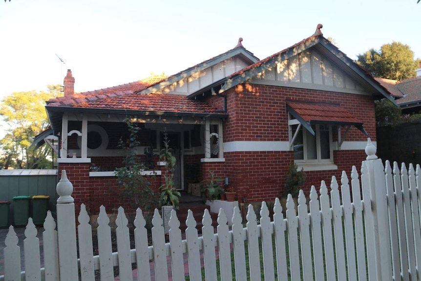 A wide shot of the front of Bob Hawke's childhood home in West Leederville, a brick and rile house with a white picket fence.