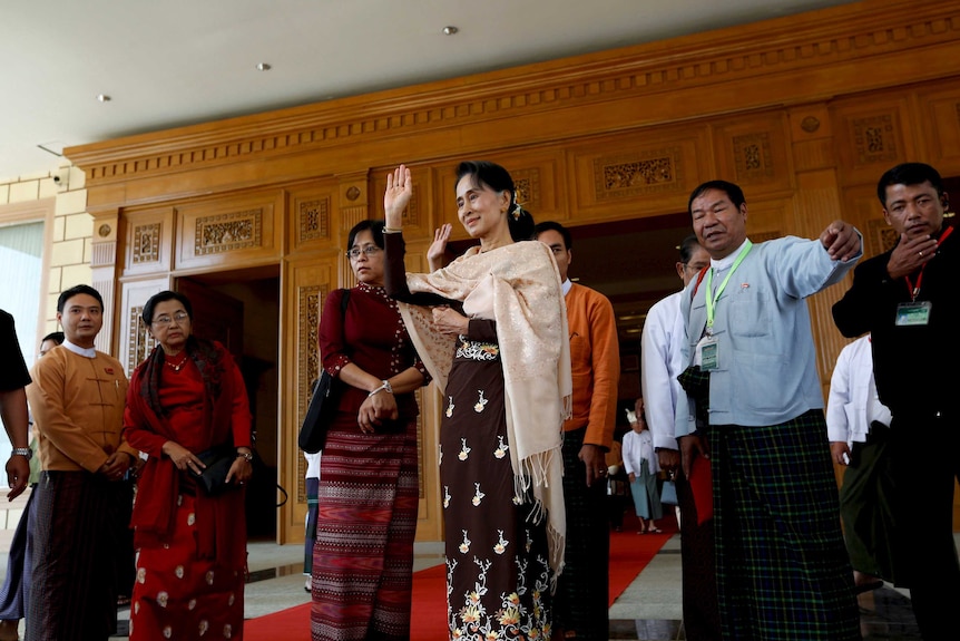 Aung San Suu Kyi stands in the Myanmar Parliament, waving