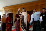 Aung San Suu Kyi stands in the Myanmar Parliament, waving