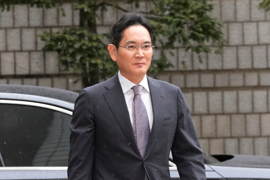 A man with glasses wearing a suit.